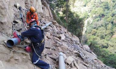 Rela Bergelantungan di Tebing Demi Saluran Air