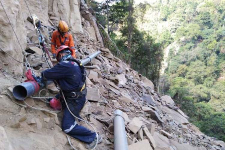 Rela Bergelantungan di Tebing Demi Saluran Air